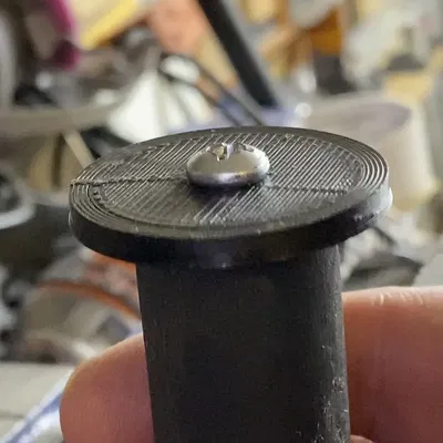 Giá đỡ cuộn filament với cạnh in gắn vào thanh gỗ