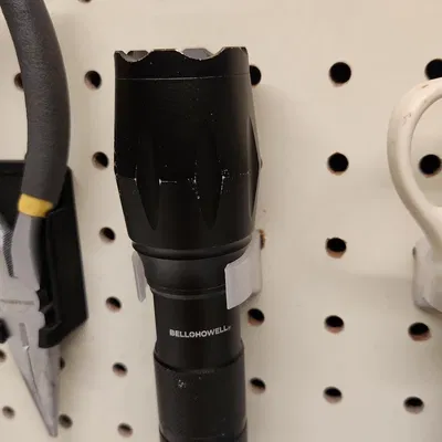 Giá đỡ đèn pin gắn vào bảng ghim tiện lợi