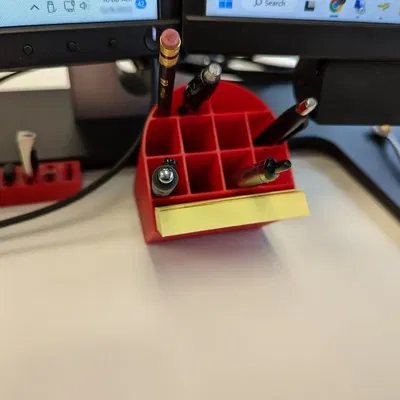 Cốc đựng bút nghiêng đặt dưới màn hình máy tính