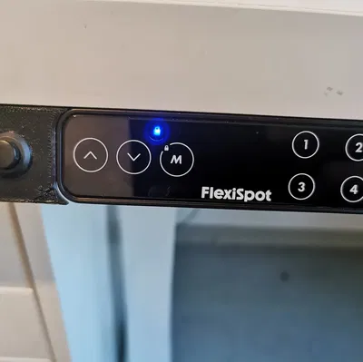 Công tắc điều khiển nguồn PC bên cạnh bảng FlexiSpot