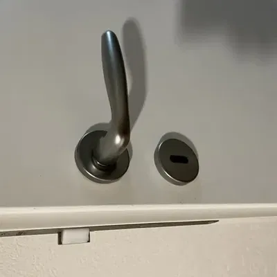 Phụ kiện nhựa dưới rosette cửa bị hỏng cần thay thế