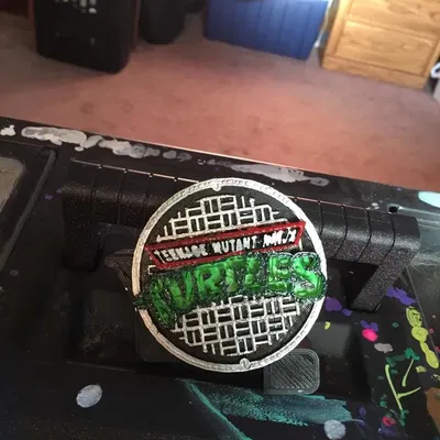 Nắp cống TMNT với logo cho khung máy xăm