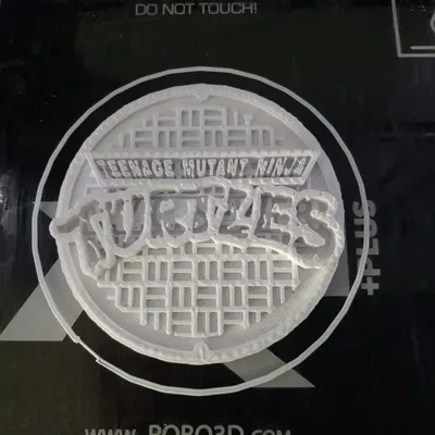 Nắp cống TMNT với logo cho khung máy xăm