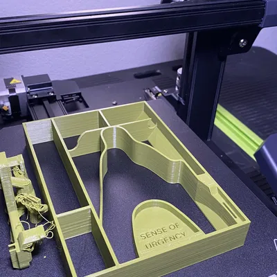 Khay để đồ Ender 3 S1 với chữ “SENSE OF URGENCY”