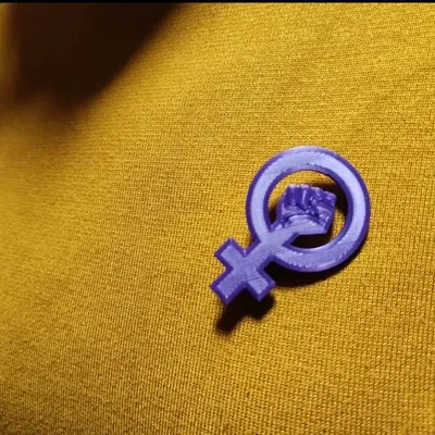 Bông cài áo với biểu tượng phong trào nữ quyền