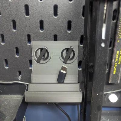 Giá đỡ điện thoại Skadis có lỗ luồn dây sạc