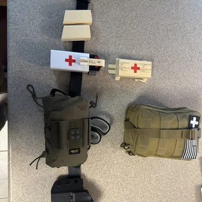 QUICK-CLIP: Bản phối lại của bao đựng băng ca (tourniquet) C.A.T gắn dây nịt