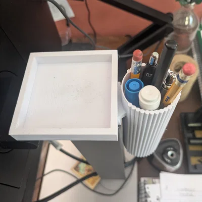 Ống cắm bút gắn cạnh bàn máy tính