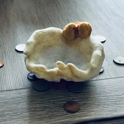 Bàn tay chụm đỡ có chim trên cổ tay (holder)