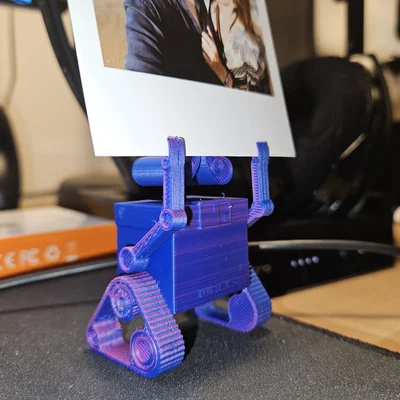 Wall‑E treo ảnh/ghi chú (Photo holding Wall‑E)