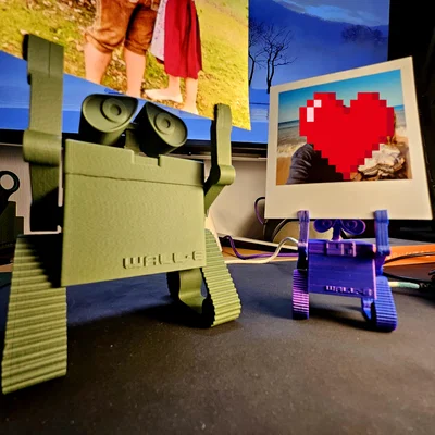 Wall‑E treo ảnh/ghi chú (Photo holding Wall‑E)