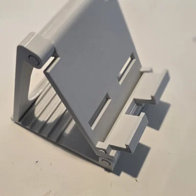 Giá đỡ điện thoại 3D gấp gọn, có khe cắm sạc tiện lợi