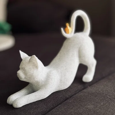 Mèo vươn mình với chim đậu trên đuôi
