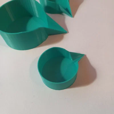 Cốc đong đo dạng dẹt có vòi rót (Measuring feeder cup with a spout)